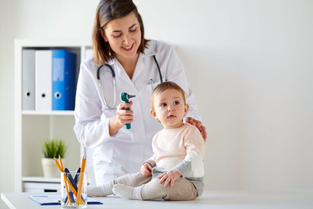 medico con bambino e otoscopio in clinica
