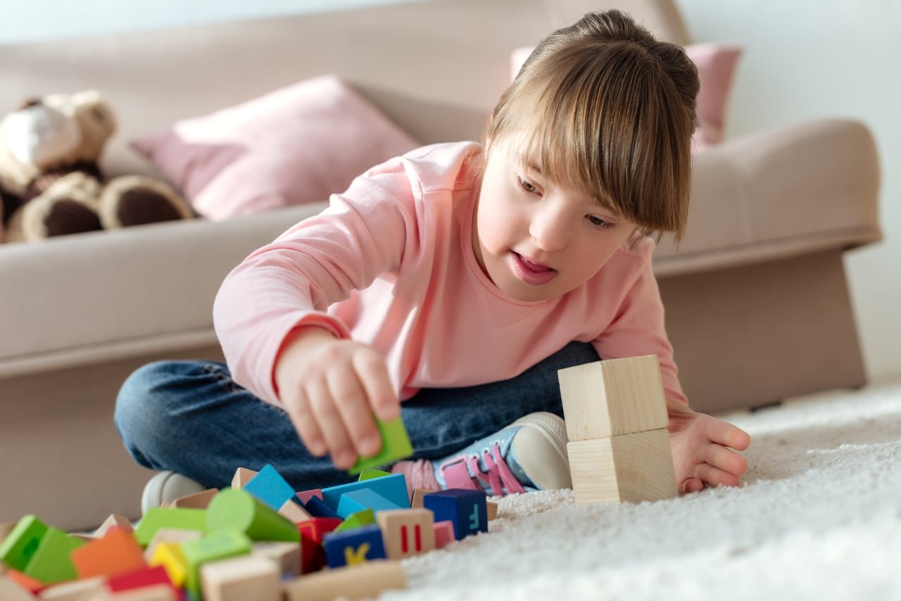 bambino con sindrome di down che gioca con i cubi giocattolo